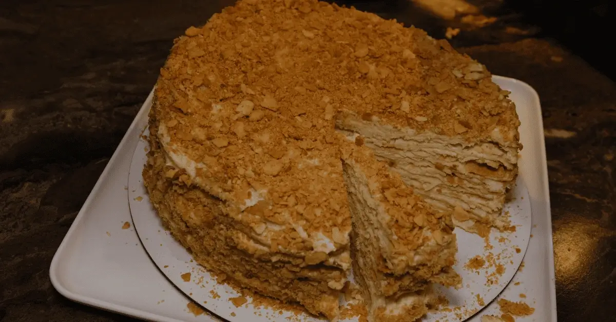 Mil Hojas cake with multiple layers of crispy pastry and a creamy filling, topped with crushed biscuits.